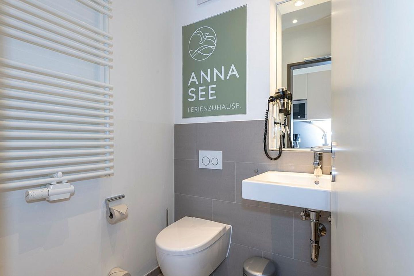 Apartmentvilla Anna See Apartmentvilla Anna See 3-05 Langeoog - Badezimmer mit Waschtisch, WC, Fön und Spiegel