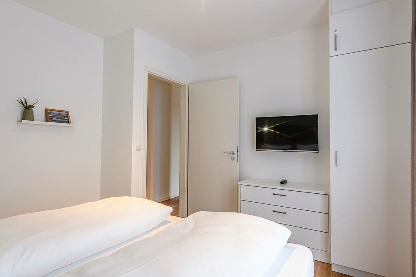 Deichhäuser Anna Küste Deichhäuser Anna Küste 1-10 Bensersiel - Schlafzimmer mit Doppelbett, Kleiderschrank und TV