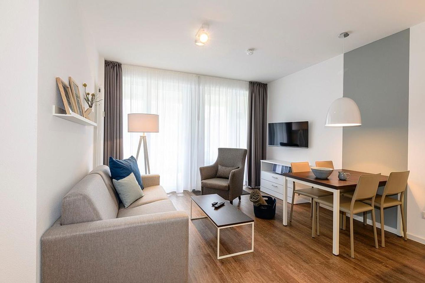 Deichhäuser Anna Küste Deichhäuser Anna Küste 1-11 Bensersiel - Wohn/Essbereich mit Sessel, Couch, TV und Esstisch