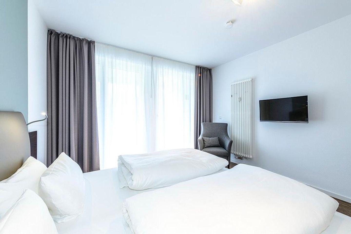 Deichhäuser Anna Küste Deichhäuser Anna Küste 1-11 Bensersiel - Schlafzimmer mit Doppelbett, Sessel und TV