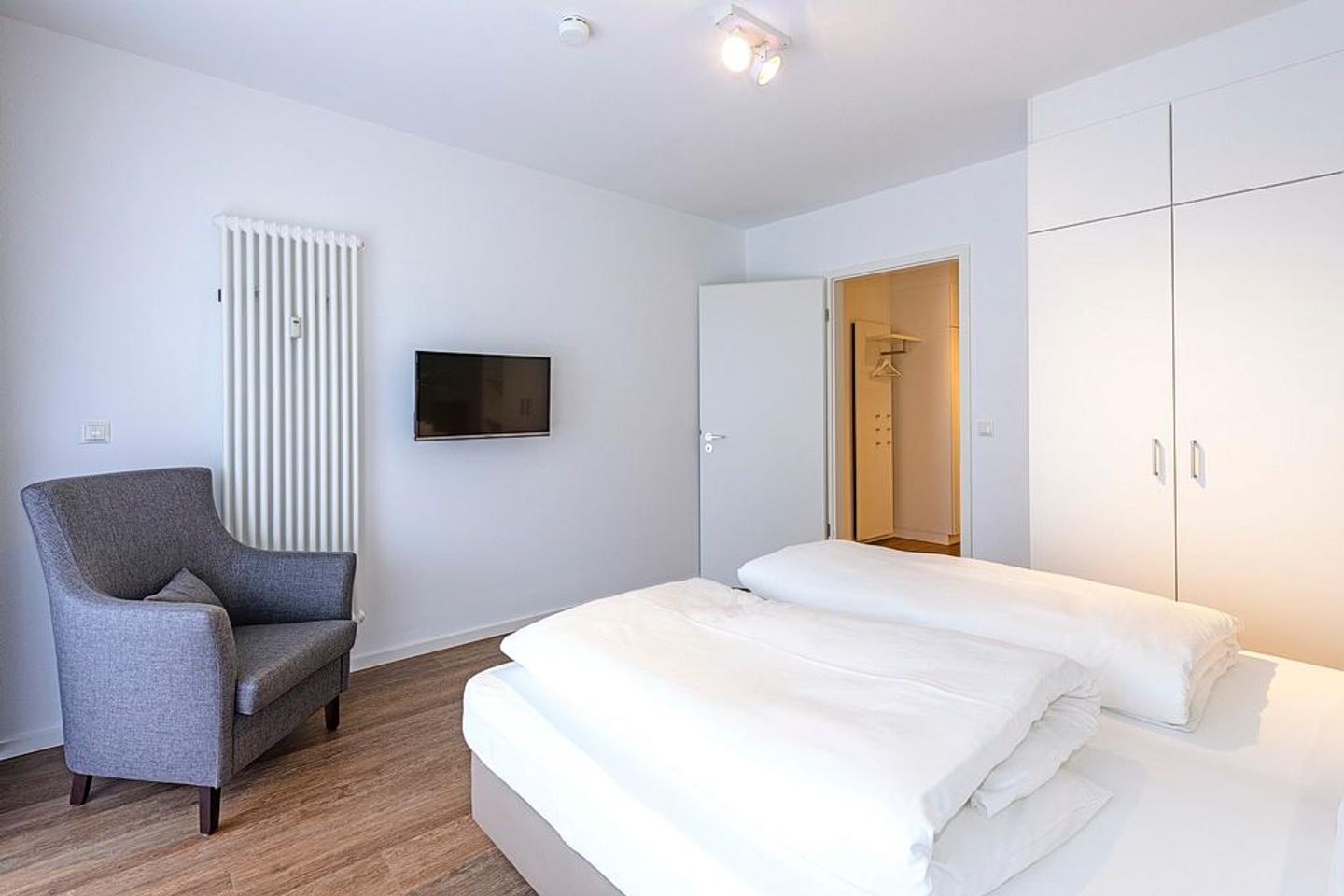 Deichhäuser Anna Küste Deichhäuser Anna Küste 1-11 Bensersiel - Schlafzimmer mit Doppelbett, Kleiderschrank und Sessel