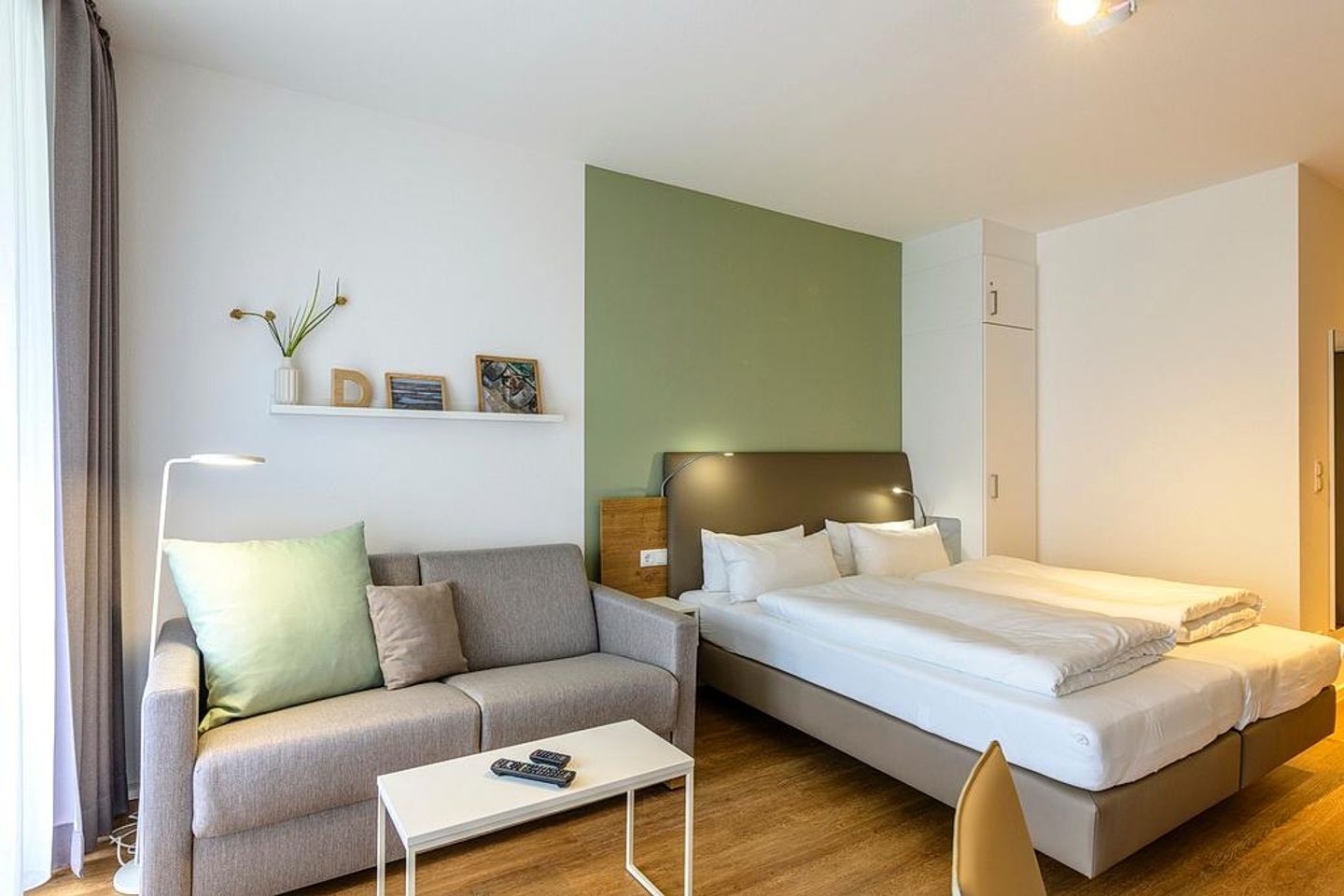 Deichhäuser Anna Küste Deichhäuser Anna Küste 1-12 Bensersiel - Wohn/Essbereich mit Couch und Doppelbett