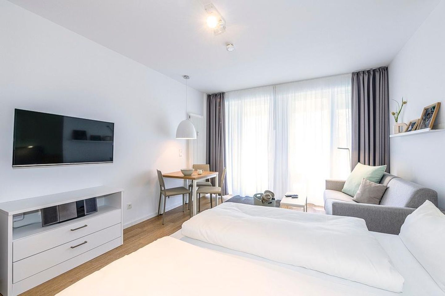 Deichhäuser Anna Küste Deichhäuser Anna Küste 1-12 Bensersiel - Wohn/Essbereich mit Doppelbett, Couch, Esstisch und TV