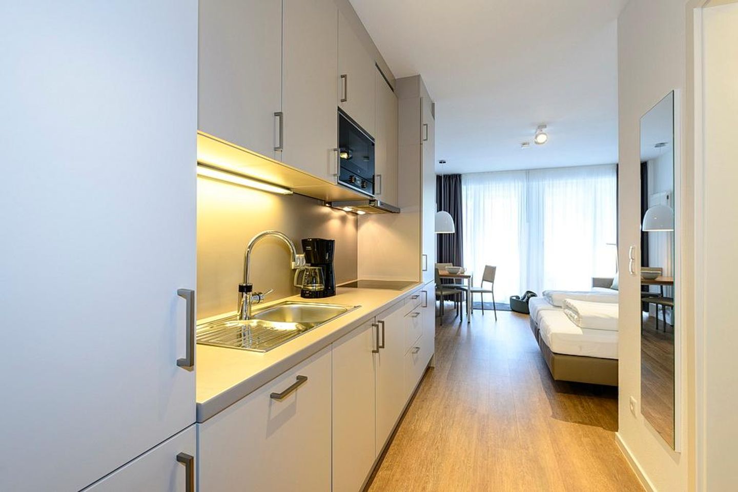 Deichhäuser Anna Küste Deichhäuser Anna Küste 1-12 Bensersiel - Wohn/Essbereich mit Küchenzeile, Esstisch und Doppelbett