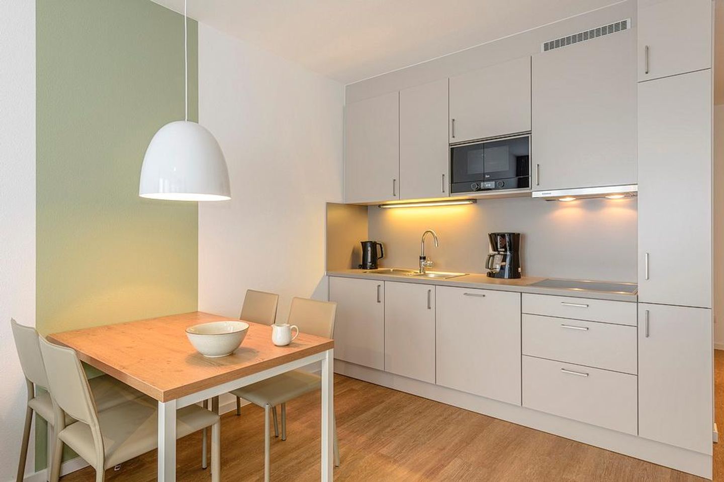 Deichhäuser Anna Küste Deichhäuser Anna Küste 1-14 Bensersiel - Wohn/Essbereich mit Esstisch und Küchenzeile