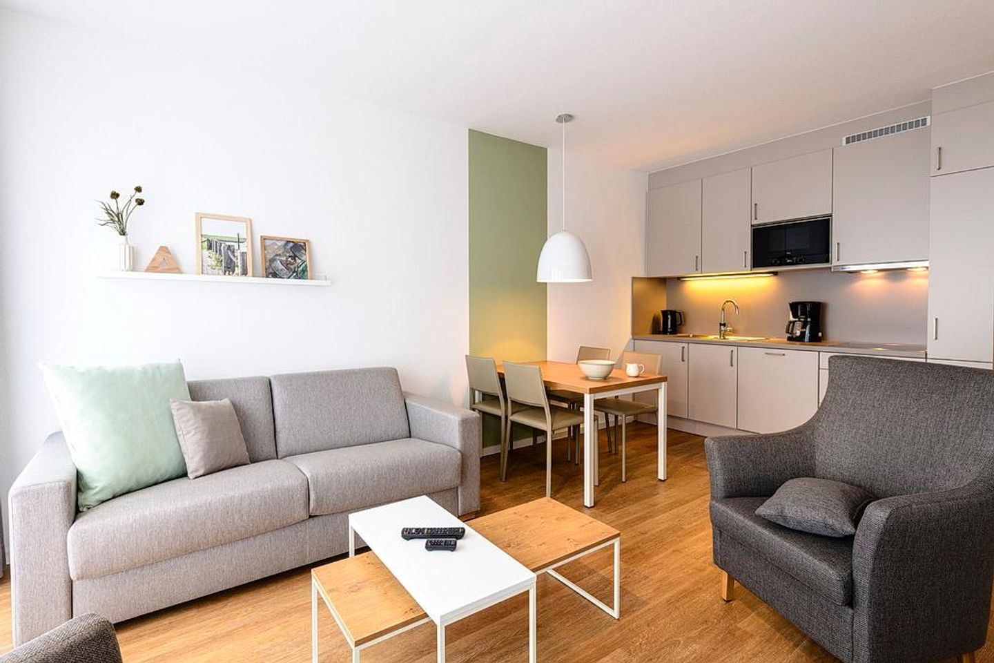 Deichhäuser Anna Küste Deichhäuser Anna Küste 1-14 Bensersiel - Wohn/Essbereich mit Couch, Sessel, Esstisch und Küchenzeile