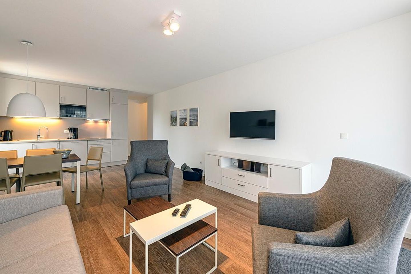 Deichhäuser Anna Küste Deichhäuser Anna Küste 1-20 Bensersiel - Wohn/Essbereich mit Sesseln, Couch, TV, Esstisch und Küchenzeile