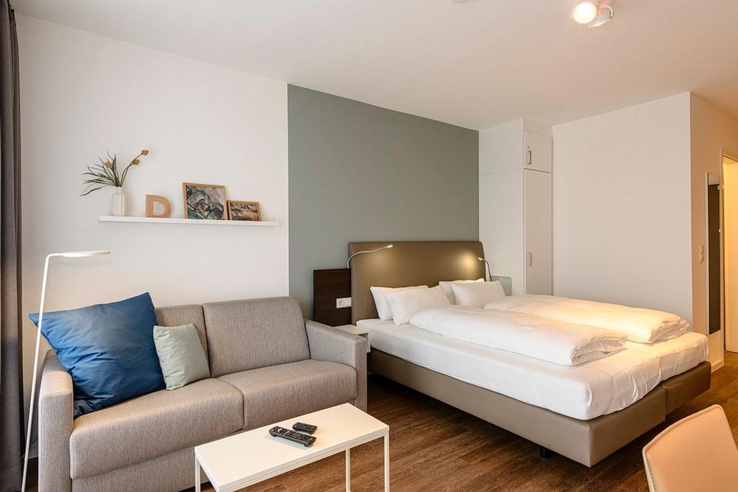 Deichhäuser Anna Küste Deichhäuser Anna Küste 1-22 Bensersiel - Wohn/Essbereich mit Doppelbett, Couch und Kleiderschrank