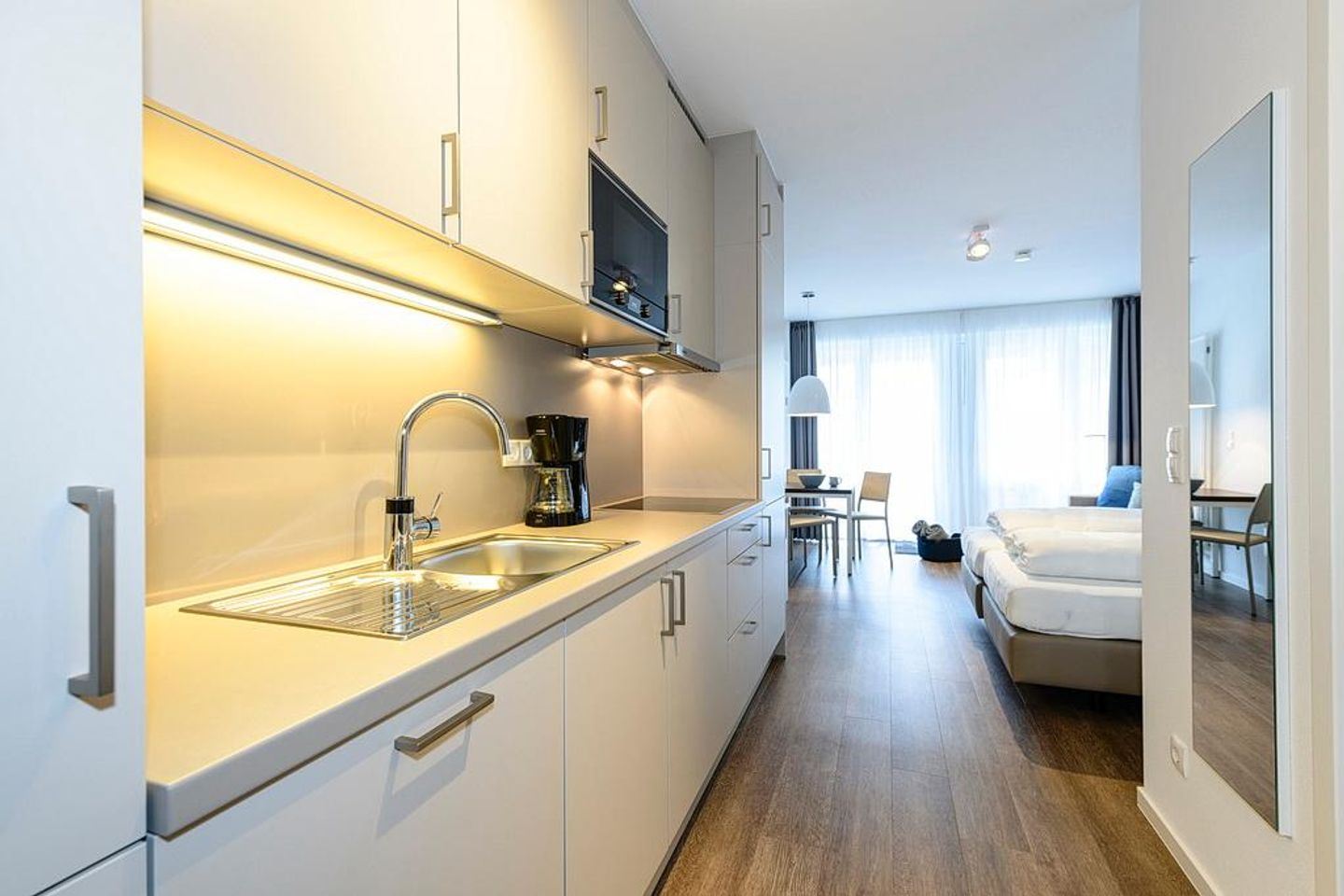 Deichhäuser Anna Küste Deichhäuser Anna Küste 1-22 Bensersiel - Wohn/Essbereich mit Küchenzeile, Doppelbett und Esstisch