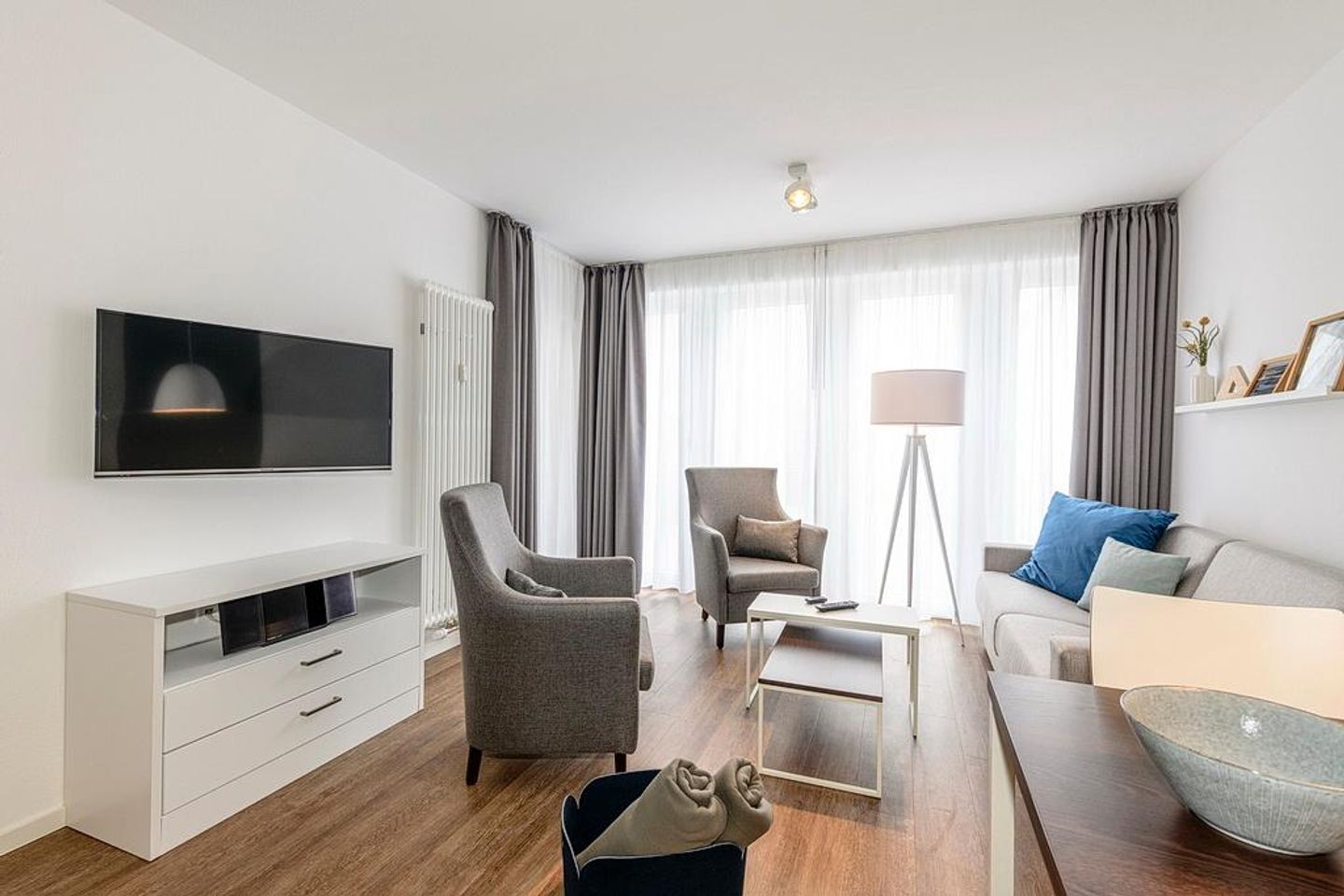 Deichhäuser Anna Küste Deichhäuser Anna Küste 1-24 Bensersiel - Wohn/Essbereich mit Esstisch, Couch, Sesseln und TV