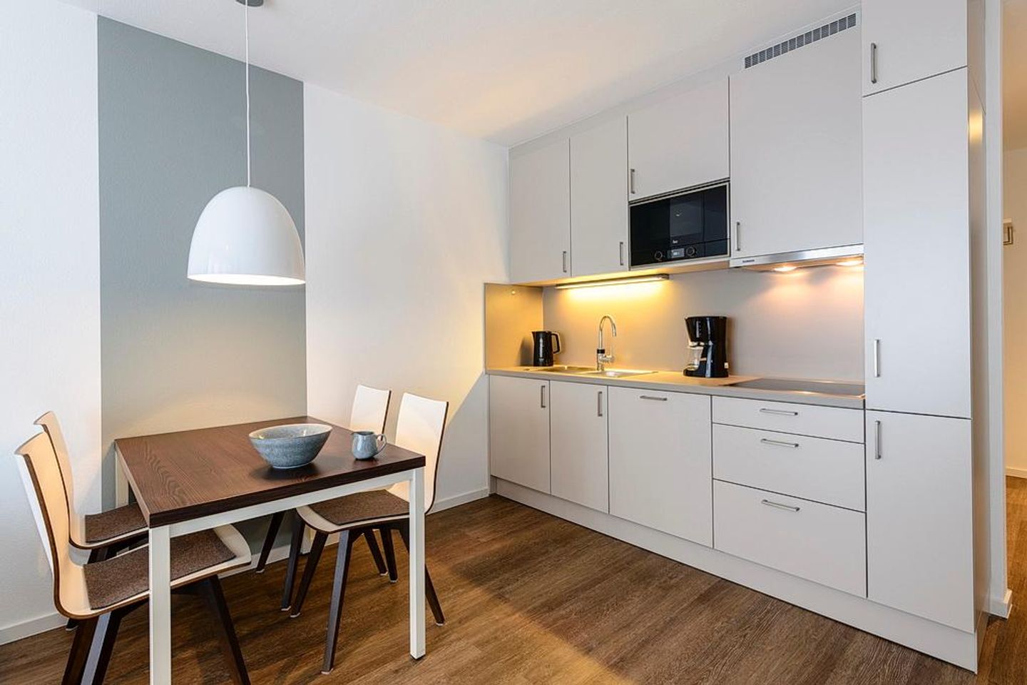 Deichhäuser Anna Küste Deichhäuser Anna Küste 1-24 Bensersiel - Wohn/Essbereich mit Küchenzeile und Esstisch