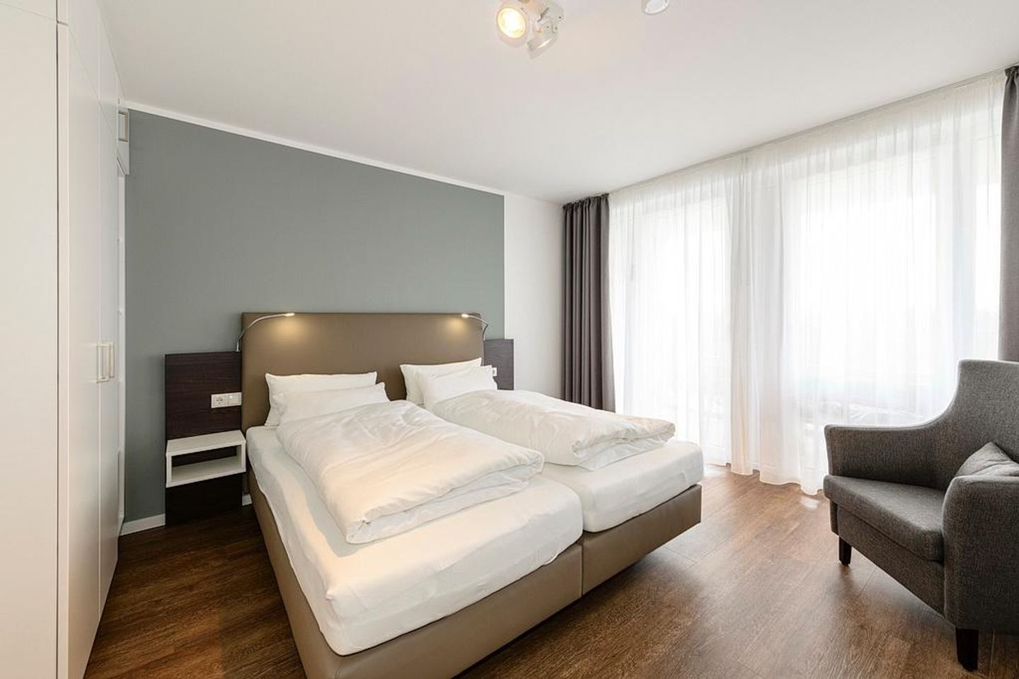 Deichhäuser Anna Küste Deichhäuser Anna Küste 1-31 Bensersiel - Schlafzimmer mit Doppelbett, Sessel und Kleiderschrank