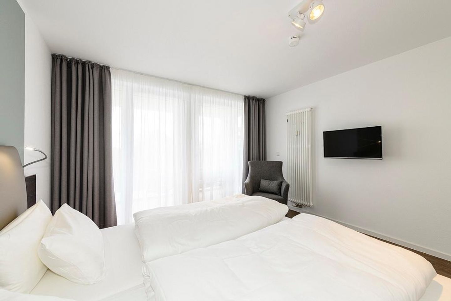 Deichhäuser Anna Küste Deichhäuser Anna Küste 1-31 Bensersiel - Schlafzimmer mit Doppelbett, Sessel und TV