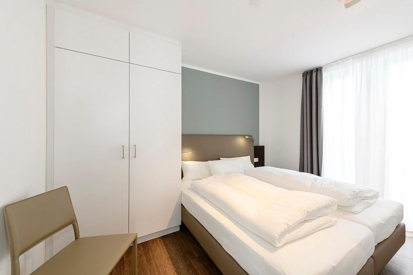 Deichhäuser Anna Küste Deichhäuser Anna Küste 1-33 Bensersiel - Schlafzimmer mit Doppelbett, Stuhl und Kleiderschrank