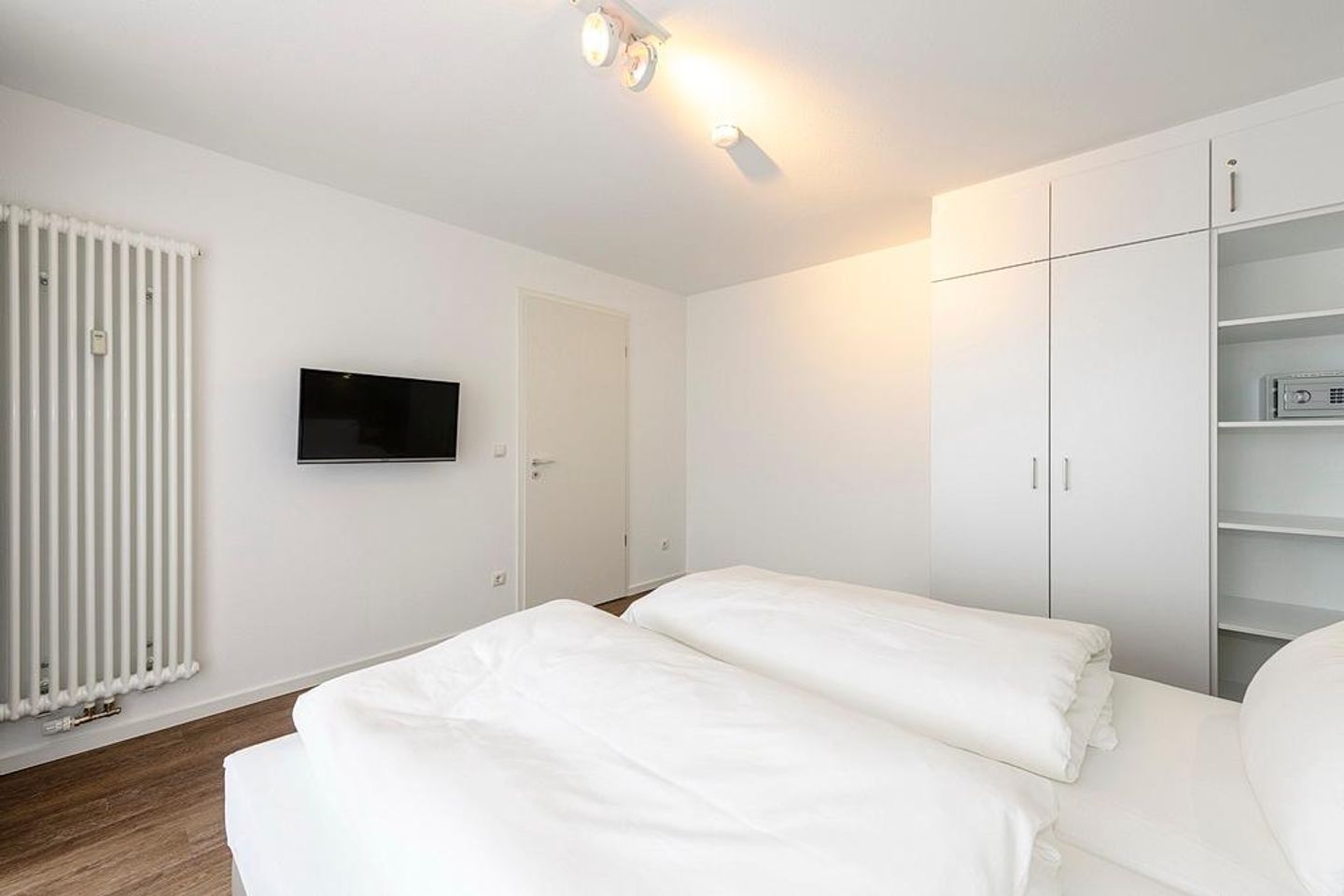 Deichhäuser Anna Küste Deichhäuser Anna Küste 1-34 Bensersiel - Schlafzimmer mit Doppelbett, TV und Kleiderschrank