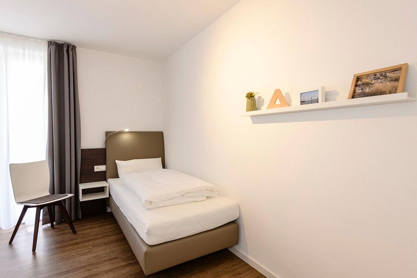 Deichhäuser Anna Küste Deichhäuser Anna Küste 1-34 Bensersiel - Schlafzimmer mit zwei Einzelbetten und Stuhl