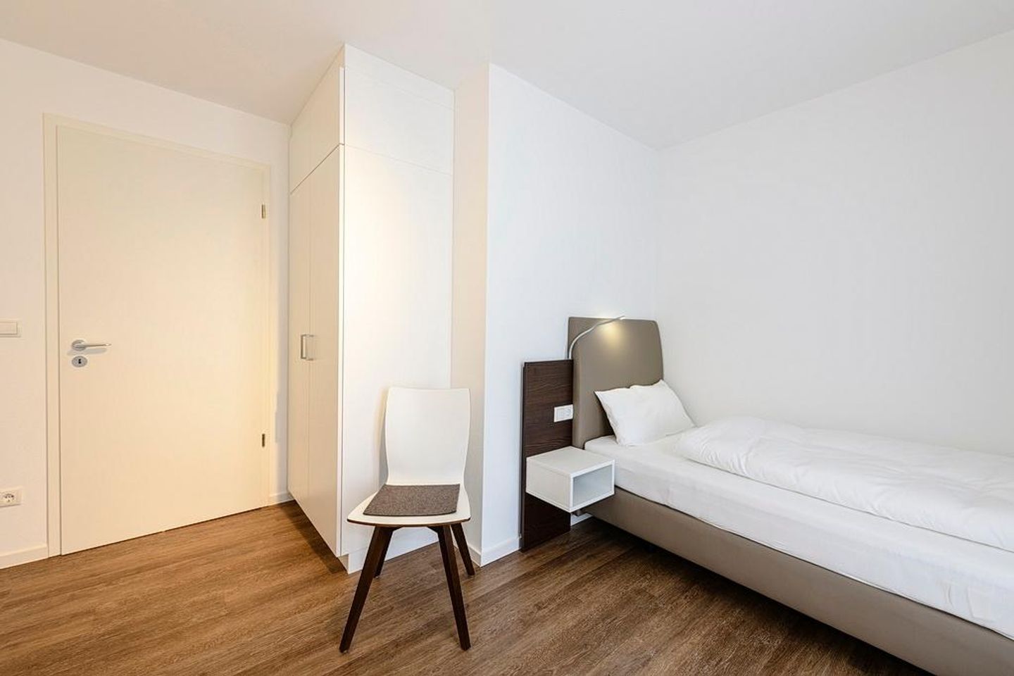 Deichhäuser Anna Küste Deichhäuser Anna Küste 1-34 Bensersiel - Schlafzimmer mit zwei Einzelbetten, Stuhl und Kleiderschrank