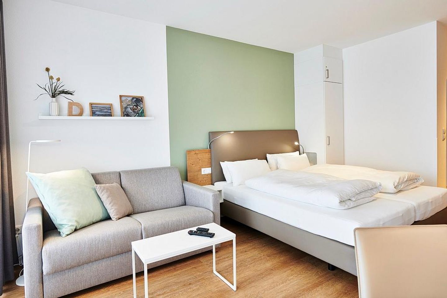 Deichhäuser Anna Küste Deichhäuser Anna Küste 2-12 Bensersiel - Wohn/Essbereich mit Couch und Doppelbett