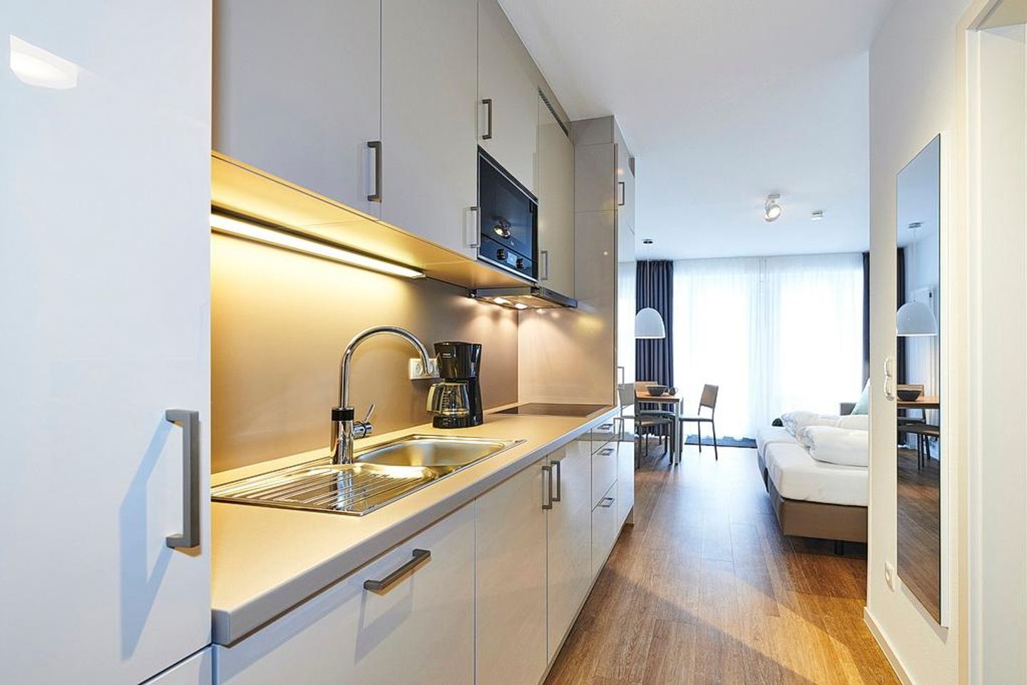 Deichhäuser Anna Küste Deichhäuser Anna Küste 2-12 Bensersiel - Wohn/Essbereich mit Küchenzeile, Doppelbett und Esstisch