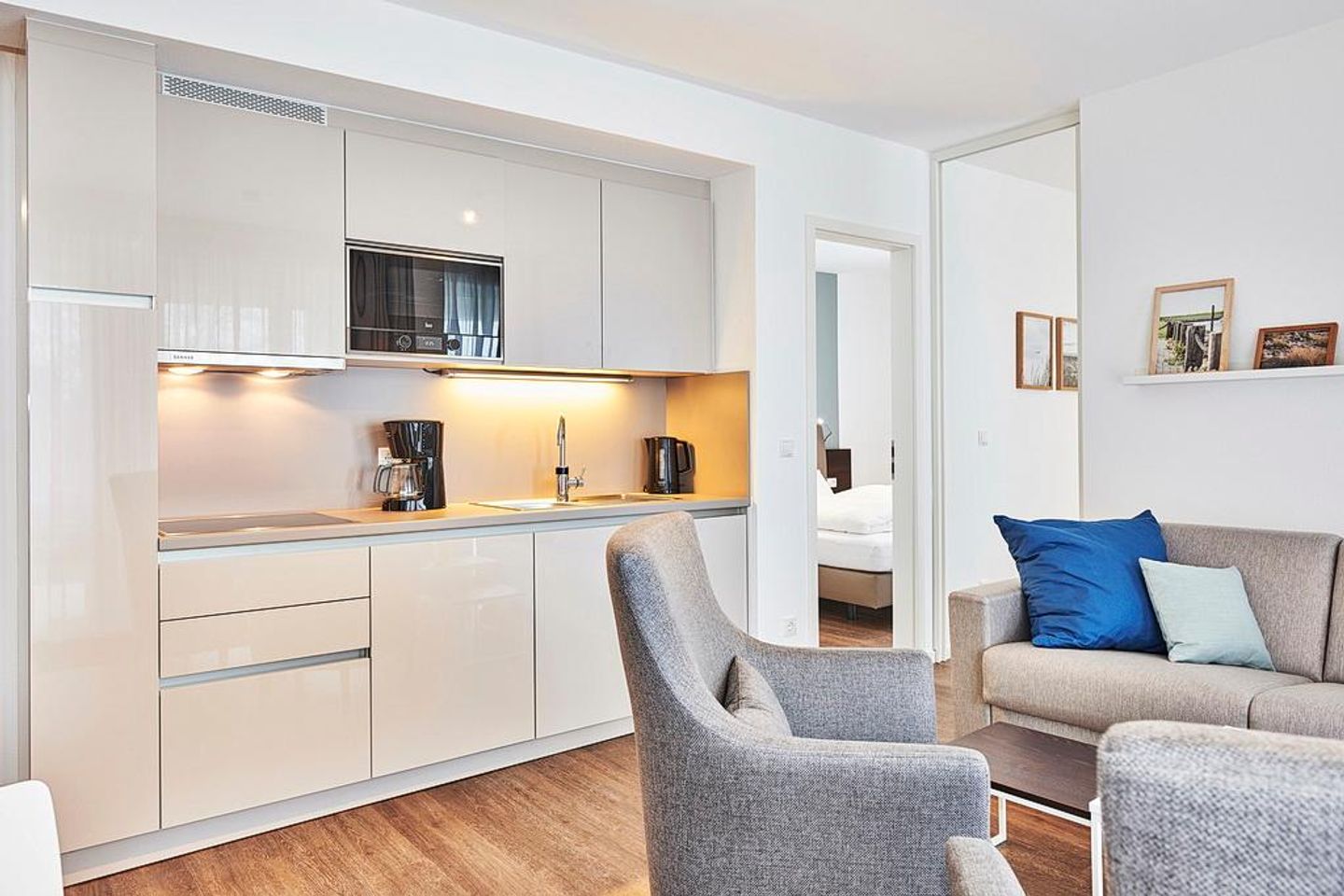 Deichhäuser Anna Küste Deichhäuser Anna Küste 2-13 Bensersiel - Wohn/Essbereich mit Küchenzeile, Couch und Sessel