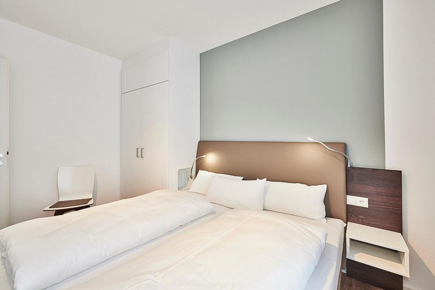 Deichhäuser Anna Küste Deichhäuser Anna Küste 2-13 Bensersiel - Schlafzimmer mit Doppelbett, Kleiderschrank und Stuhl