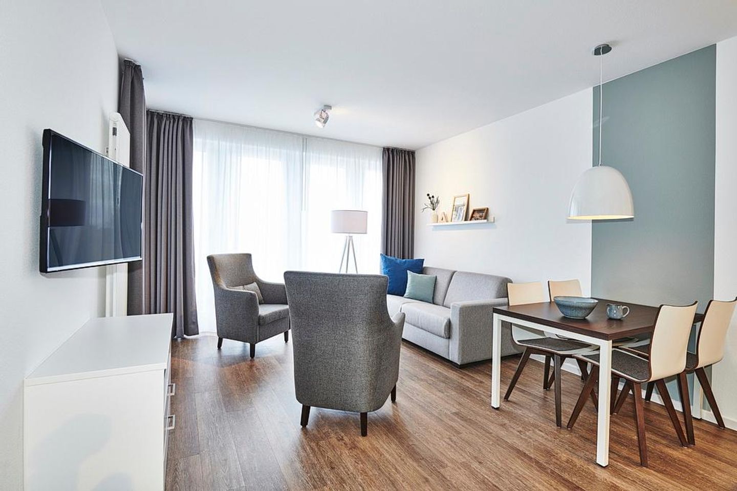 Deichhäuser Anna Küste Deichhäuser Anna Küste 2-14 Bensersiel - Wohn/Essbereich mit Esstisch, Couch, Sesseln und TV