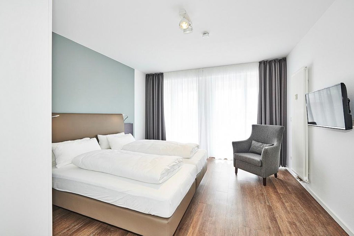 Deichhäuser Anna Küste Deichhäuser Anna Küste 2-21 Bensersiel - Schlafzimmer mit Doppelbett, Sessel und TV