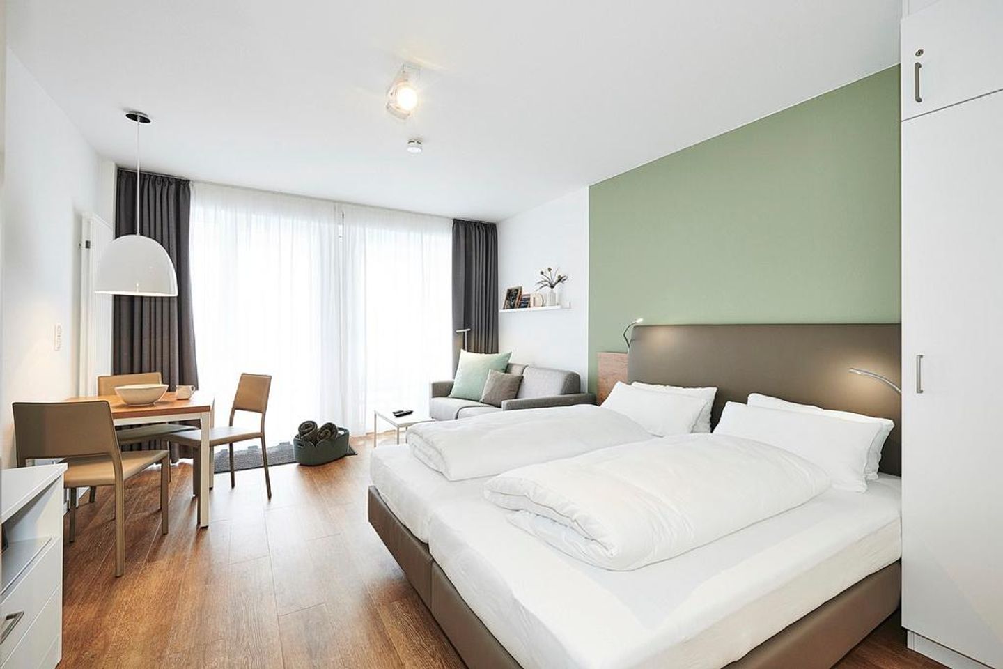 Deichhäuser Anna Küste Deichhäuser Anna Küste 2-22 Bensersiel - Wohn/Essbereich mit Doppelbett, Esstisch und Couch