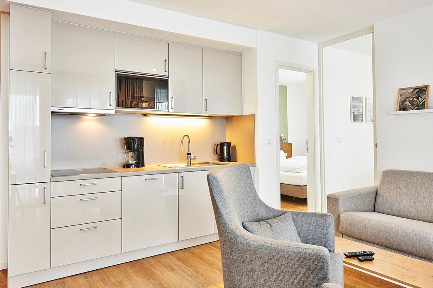 Deichhäuser Anna Küste Deichhäuser Anna Küste 2-23 Bensersiel - Wohn/Essbereich mit Sessel, Couch und Küchenzeile