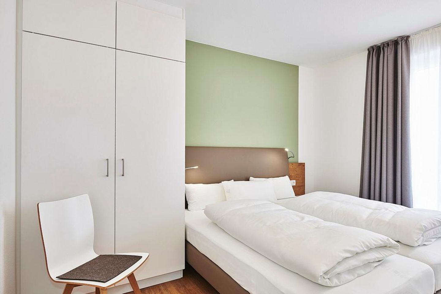 Deichhäuser Anna Küste Deichhäuser Anna Küste 2-23 Bensersiel - Schlafzimmer mit Doppelbett, Kleiderschrank und Stuhl