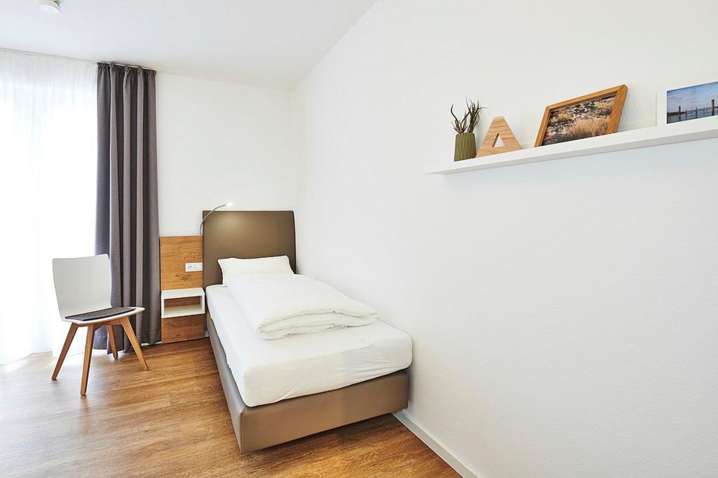 Deichhäuser Anna Küste Deichhäuser Anna Küste 2-24 Bensersiel - Schlafzimmer mit zwei Einzelbetten und Stuhl