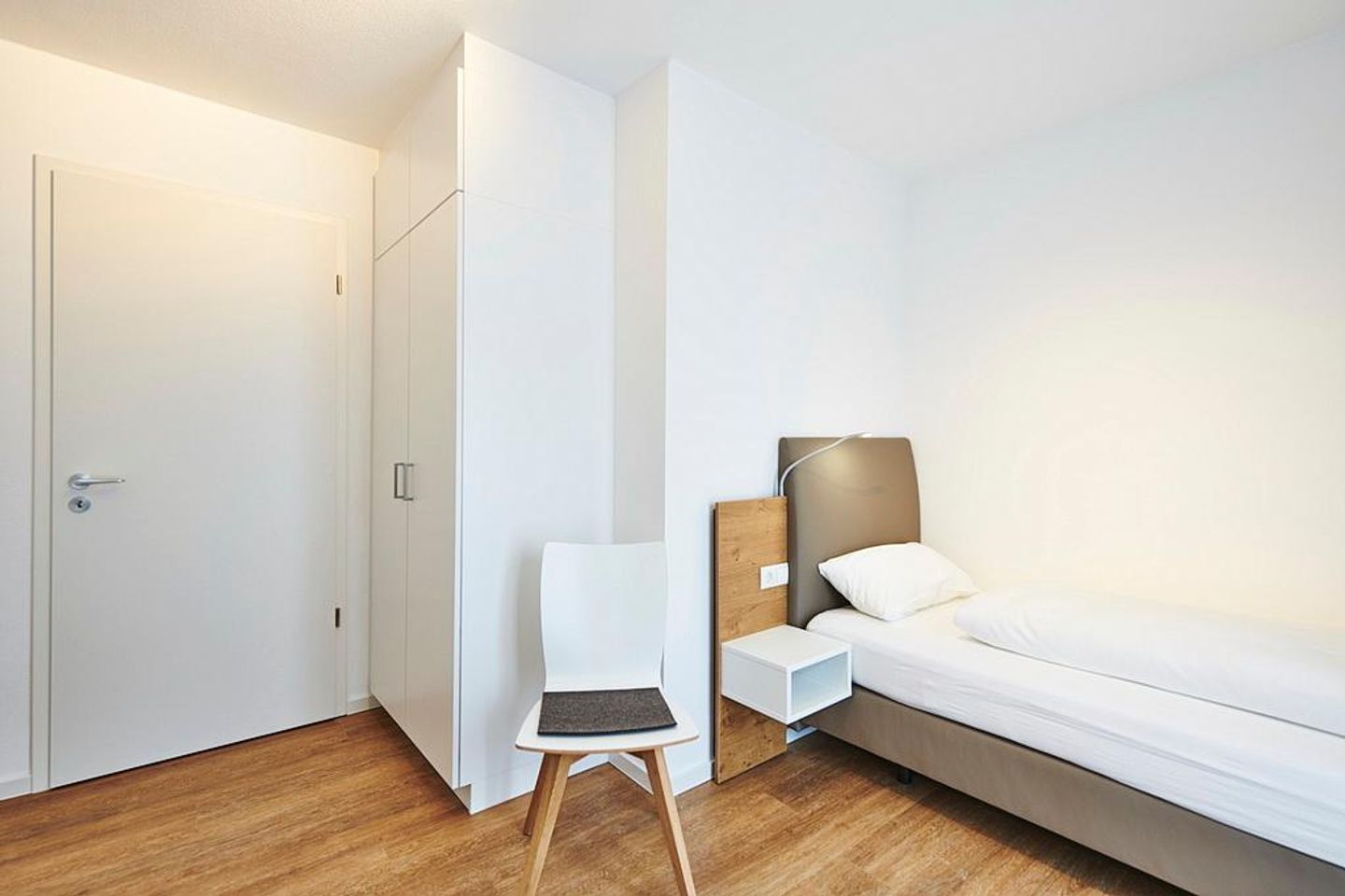 Deichhäuser Anna Küste Deichhäuser Anna Küste 2-24 Bensersiel - Schlafzimmer mit zwei Einzelbetten, Kleiderschrank und Stuhl