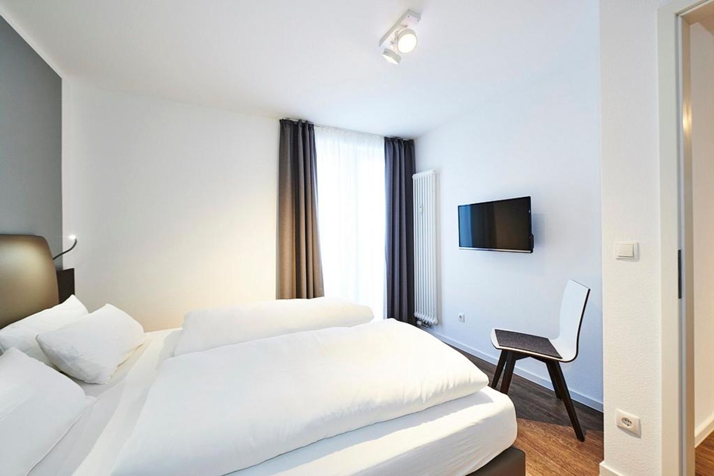 Deichhäuser Anna Küste Deichhäuser Anna Küste 2-30 Bensersiel - Schlafzimmer mit Doppelbett, Stuhl und TV