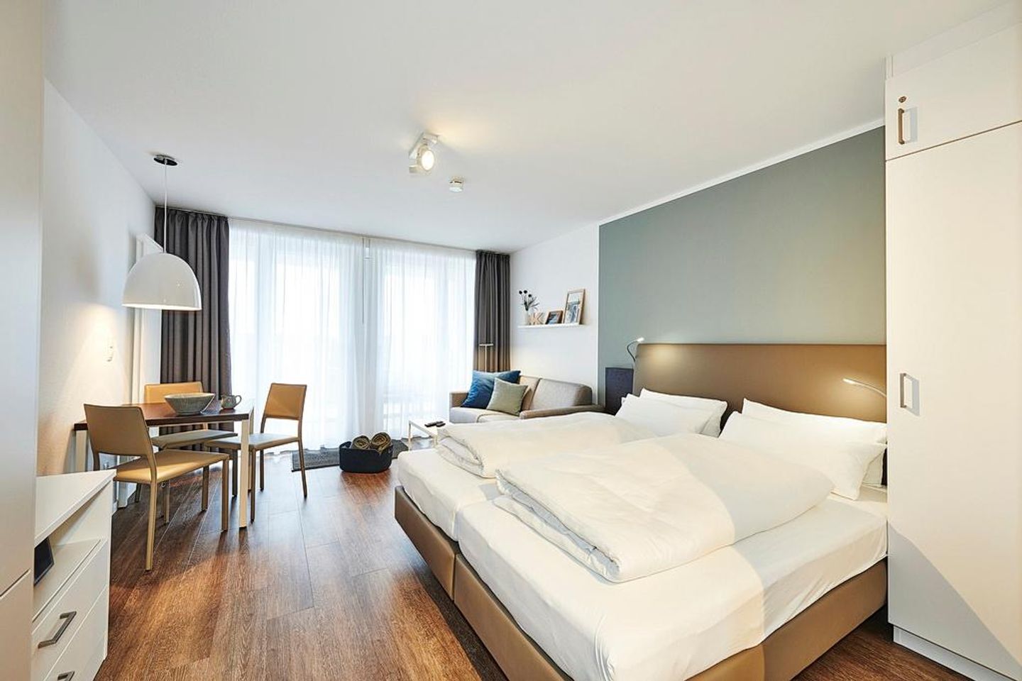 Deichhäuser Anna Küste Deichhäuser Anna Küste 2-32 Bensersiel - Wohn/Essbereich mit Doppelbett, Esstisch und Couch