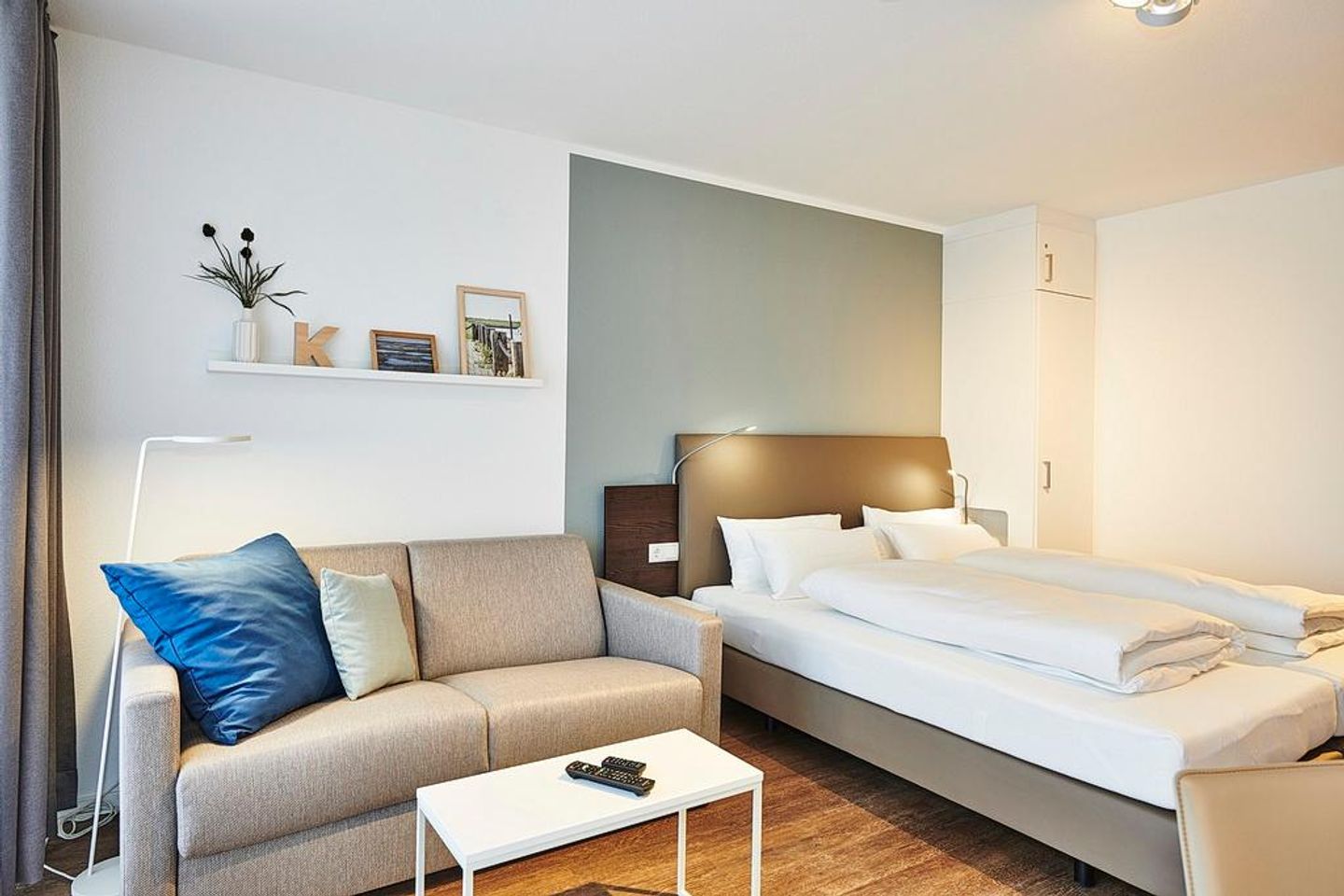 Deichhäuser Anna Küste Deichhäuser Anna Küste 2-32 Bensersiel - Wohn/Essbereich mit Couch, Doppelbett und Kleiderschrank