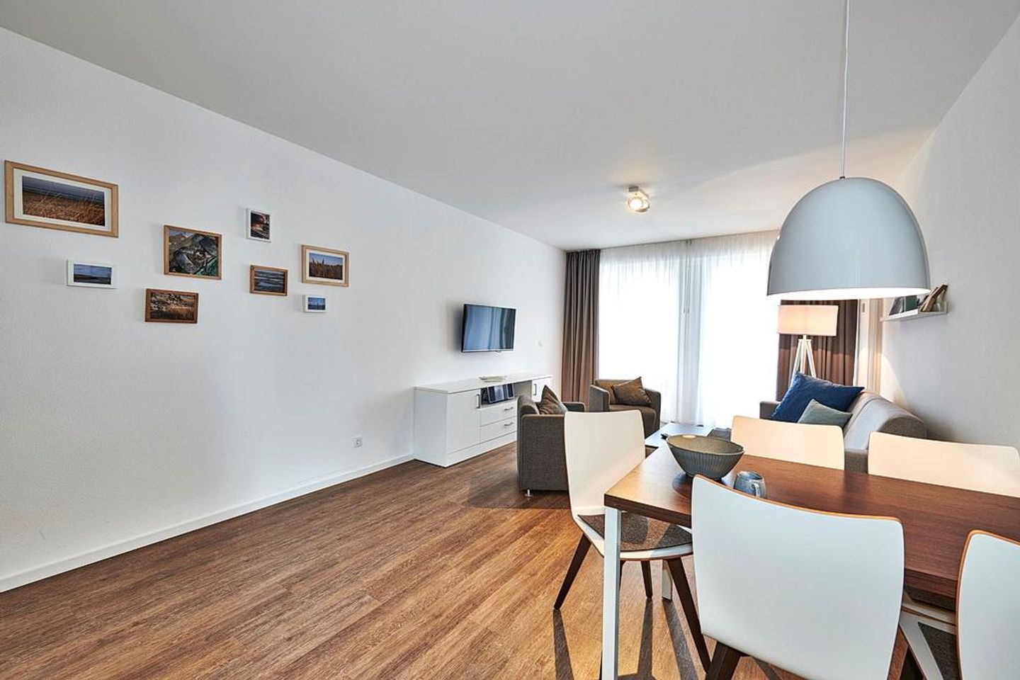 Deichhäuser Anna Küste Deichhäuser Anna Küste 3-10 Bensersiel - Wohn/Essbereich mit Esstisch, Sessel, Couch und TV