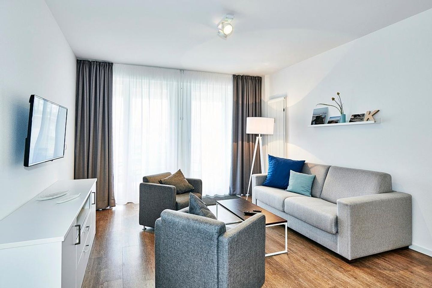 Deichhäuser Anna Küste Deichhäuser Anna Küste 3-10 Bensersiel - Wohn/Essbereich mit Sesseln, Couch und TV