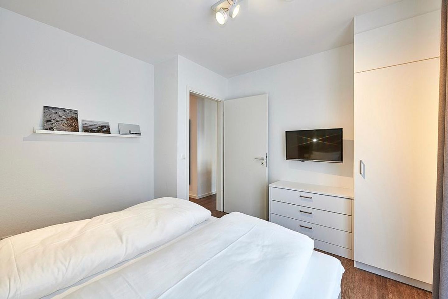 Deichhäuser Anna Küste Deichhäuser Anna Küste 3-10 Bensersiel - Schlafzimmer mit Doppelbett, Kleiderschrank und TV