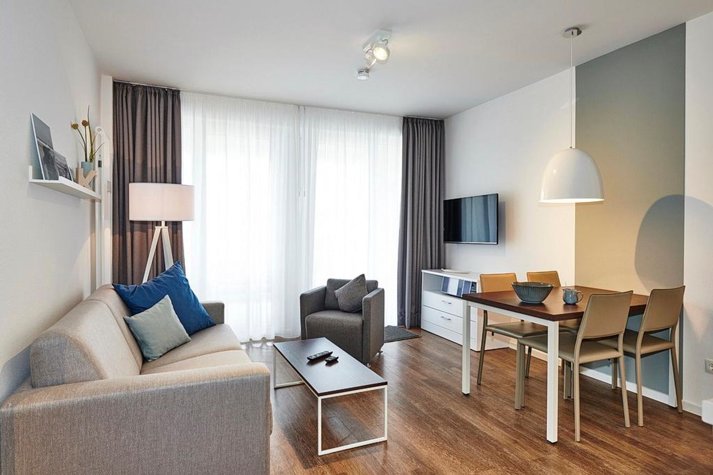 Deichhäuser Anna Küste Deichhäuser Anna Küste 3-11 Bensersiel - Wohn/Essbereich mit Couch, Sessel, Esstisch und TV