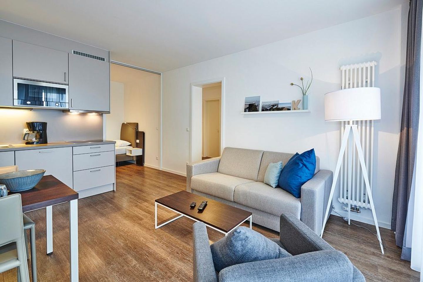 Deichhäuser Anna Küste Deichhäuser Anna Küste 3-11 Bensersiel - Wohn/Essbereich mit Sessel, Couch, Esstisch und Küchenzeile