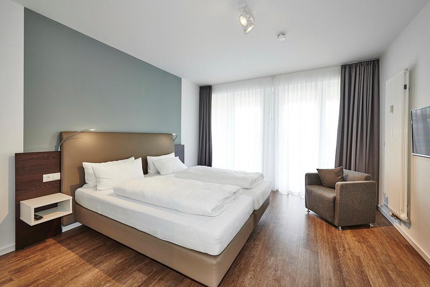 Deichhäuser Anna Küste Deichhäuser Anna Küste 3-11 Bensersiel - Schlafzimmer mit Doppelbett und Sessel