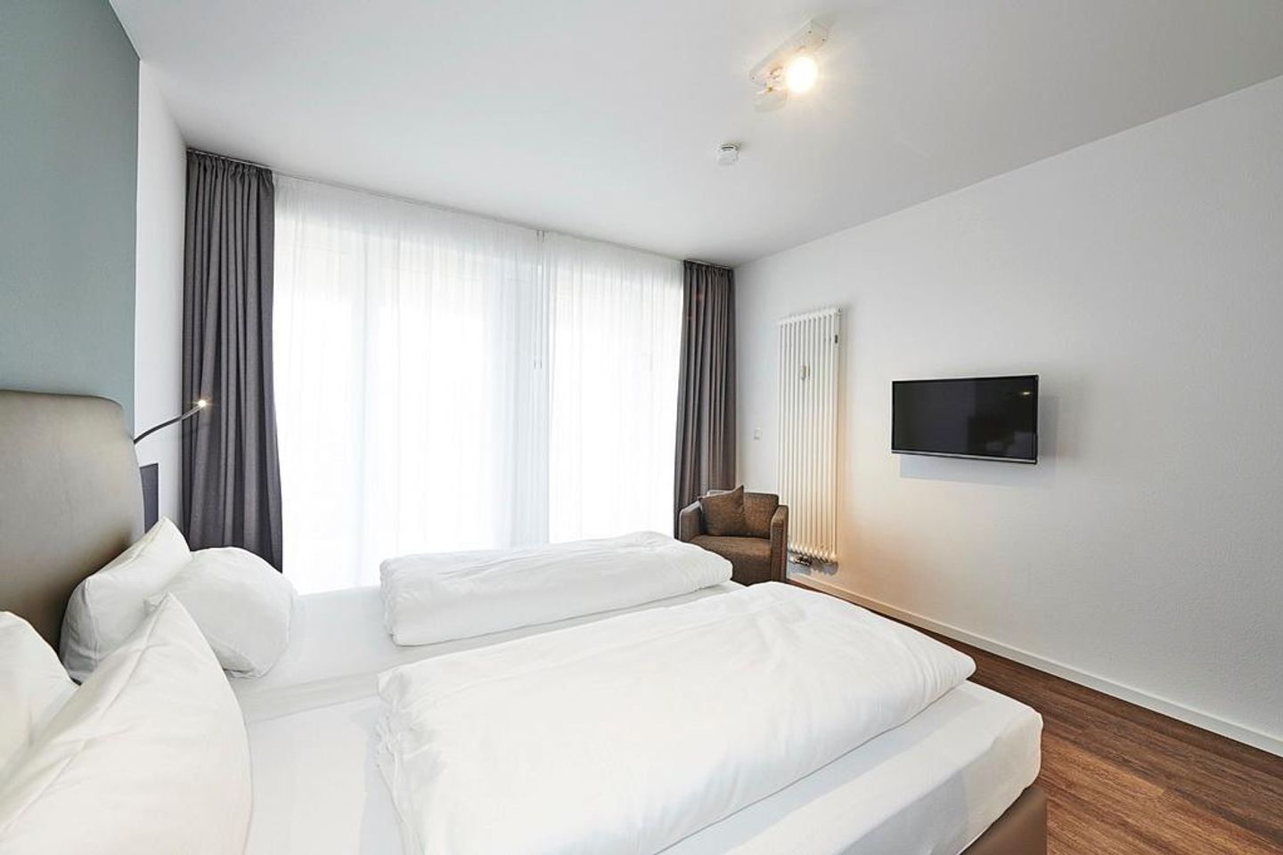 Deichhäuser Anna Küste Deichhäuser Anna Küste 3-11 Bensersiel - Schlafzimmer mit Doppelbett, Sessel und TV