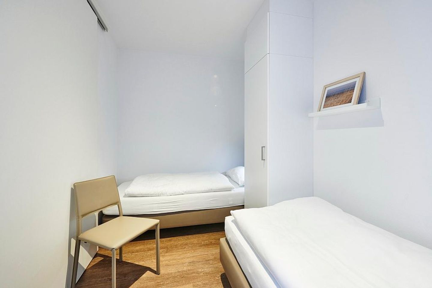 Deichhäuser Anna Küste Deichhäuser Anna Küste 3-11 Bensersiel - Schlafzimmer mit zwei Einzelbetten, Stuhl und Kleiderschrank