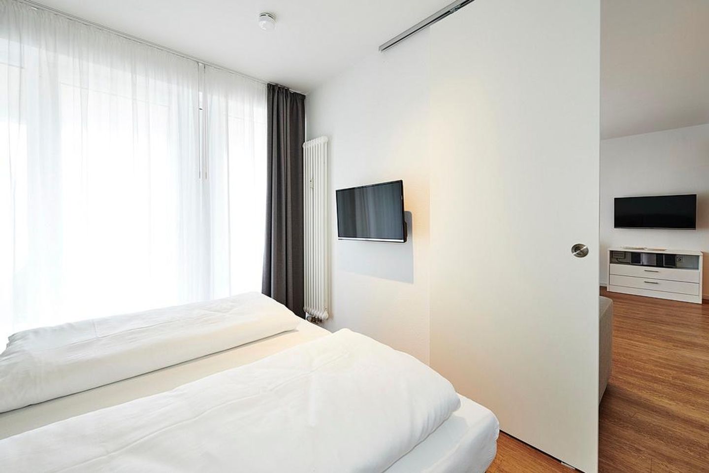 Deichhäuser Anna Küste Deichhäuser Anna Küste 3-13 Bensersiel - Schlafbereich mit Flatscreen-TV, Blick in den Wohnbereich