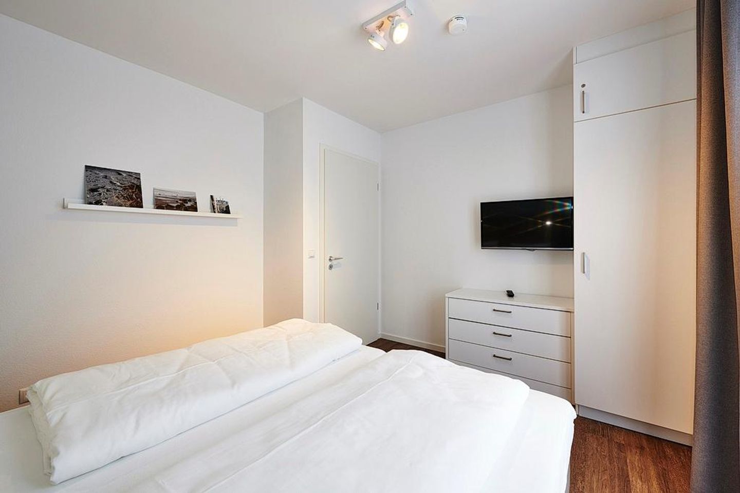 Deichhäuser Anna Küste Deichhäuser Anna Küste 3-20 Bensersiel - Schlafzimmer mit Doppelbett, Kleiderschrank und Flatscreen-TV