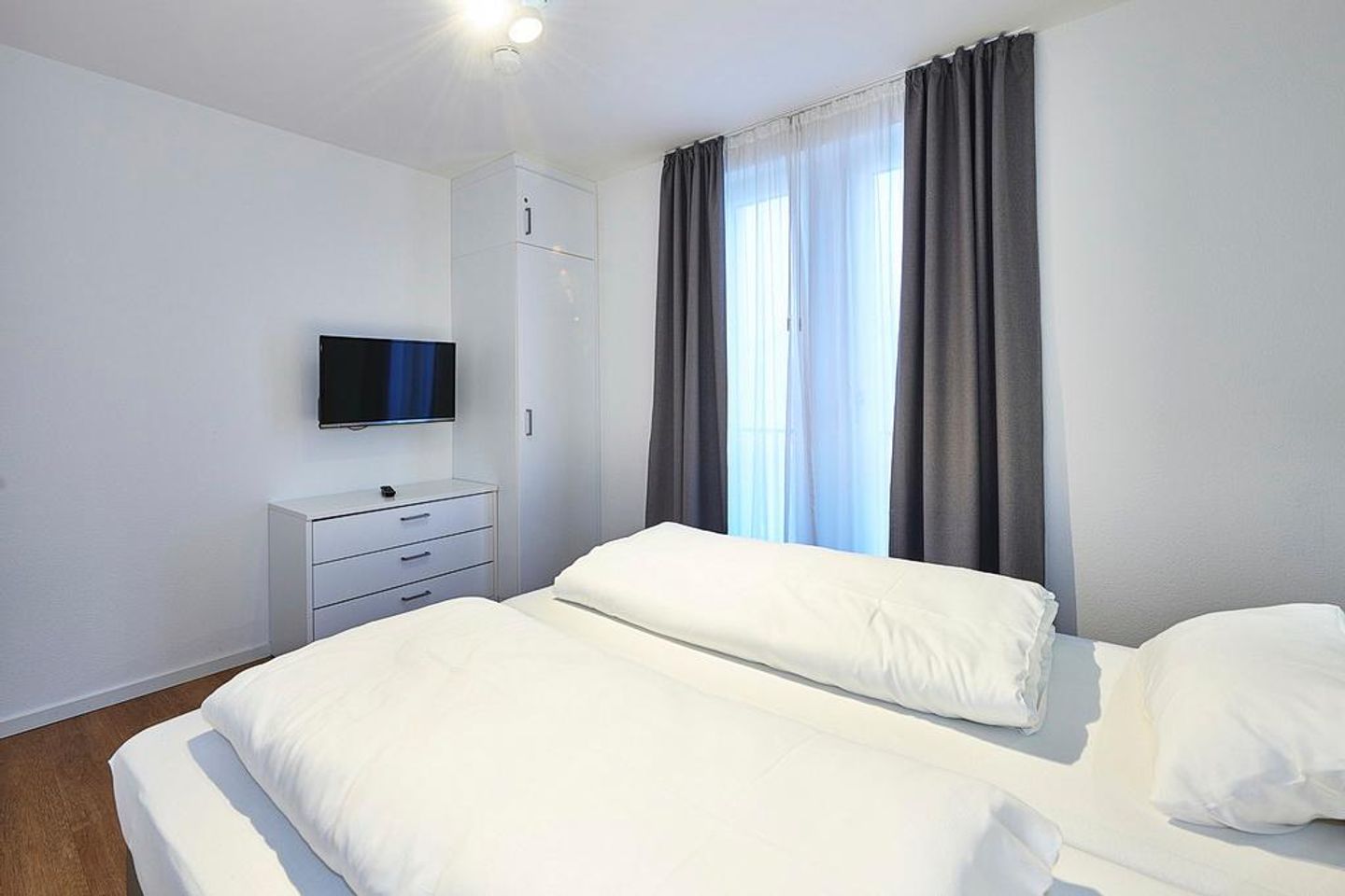 Deichhäuser Anna Küste Deichhäuser Anna Küste 3-30 Bensersiel - Schlafbereich mit Doppelbett und Flatscreen TV