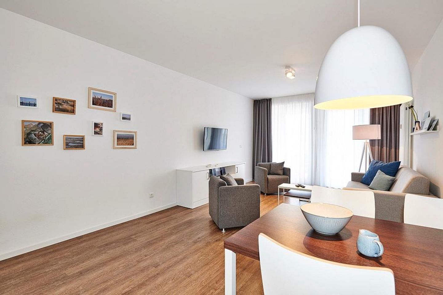 Deichhäuser Anna Küste Deichhäuser Anna Küste 4-10 Bensersiel - Wohnbereich mit Couch, Sesseln und Flatscreen-TV