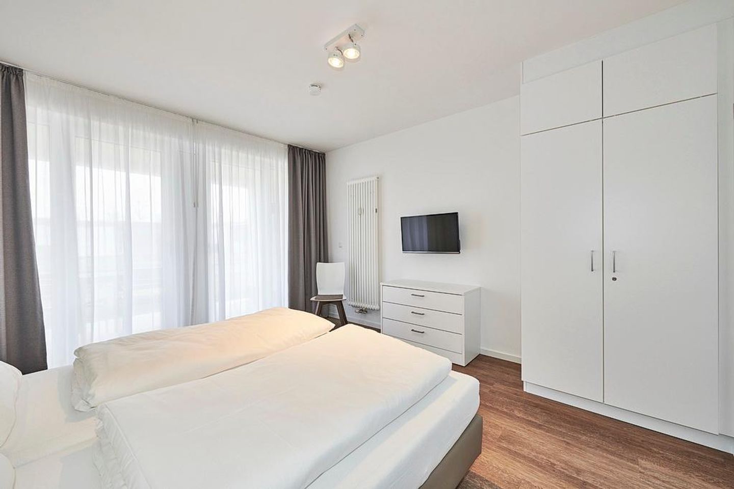 Deichhäuser Anna Küste Deichhäuser Anna Küste 4-11 Bensersiel - Schlafzimmer mit Doppelbett, Flatscreen-TV und Kleiderschrank