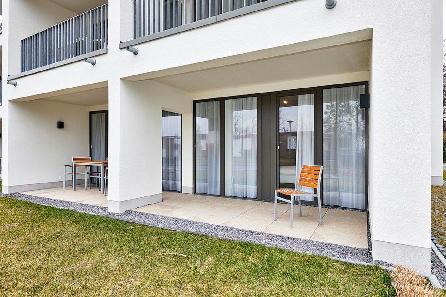 Deichhäuser Anna Küste Deichhäuser Anna Küste 4-13 Bensersiel - Überdachte Terrasse mit Sitzgelegenheit und Grünfläche