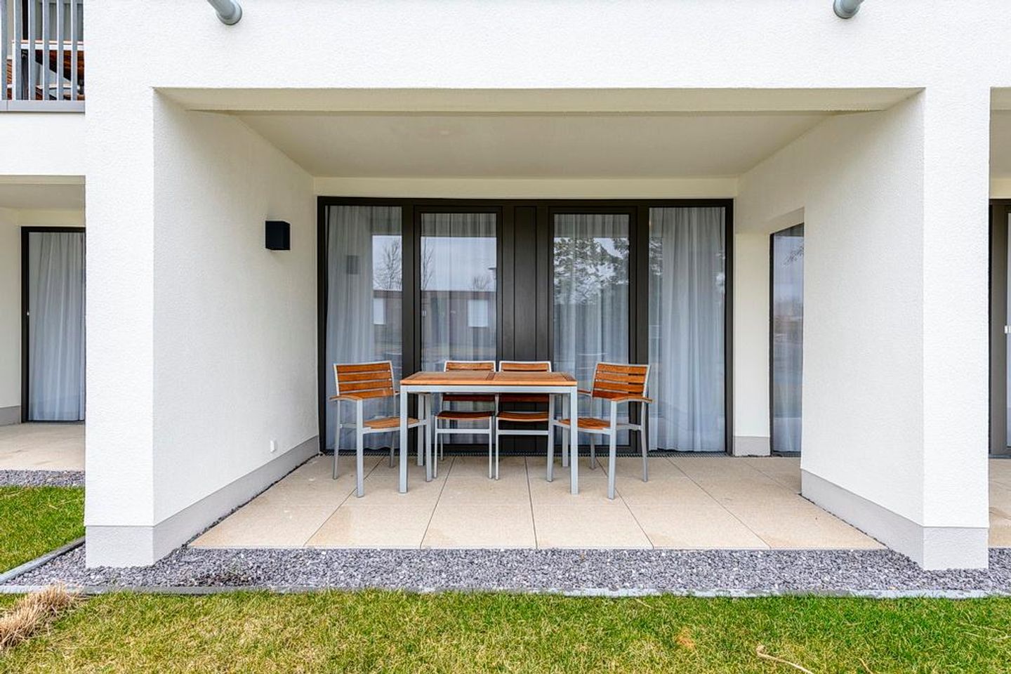 Deichhäuser Anna Küste Deichhäuser Anna Küste 4-13 Bensersiel - Überdachte Terrasse mit Sitzgelegenheit und Grünfläche